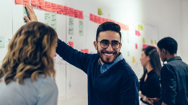 Vier Personen vor Wand mit Post-its