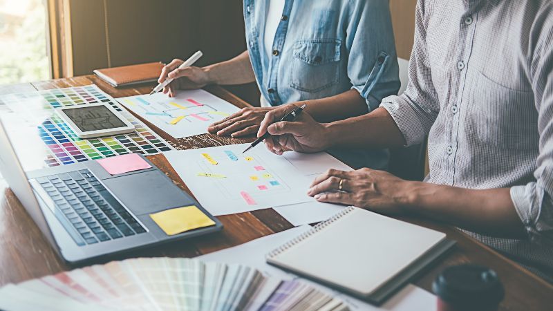 Frau mit Schreibstift und Mann mit Tabletcomputer im Gespräch