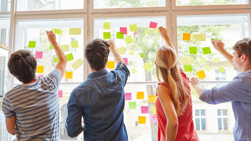 Vier Personen vor Fenster mit Post-its