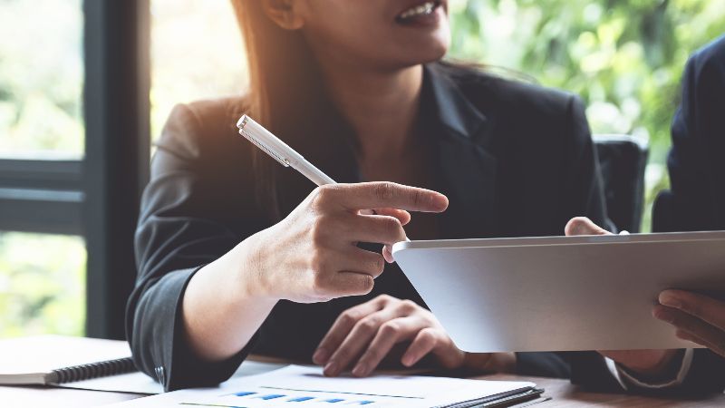 Frau mit Schreibstift und Tabletcomputer im Gespräch